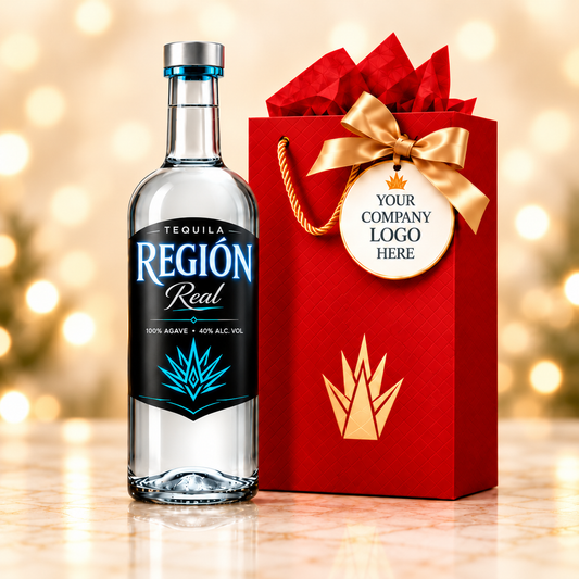Región Real Plata tequila beside a red gift bag with a company logo tag